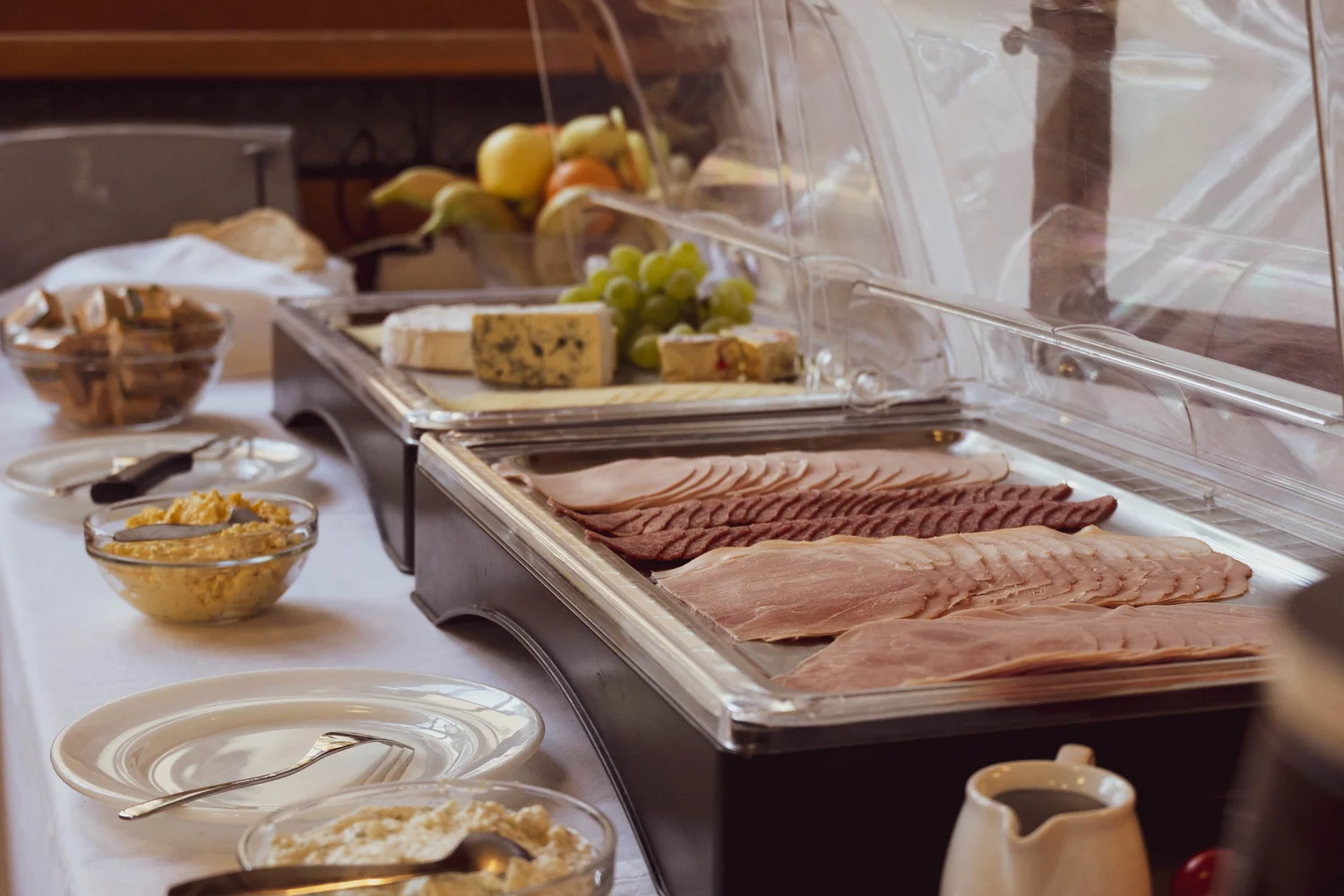 Hotel breakfast buffet with charcuterie, cheese, fruit, and bread